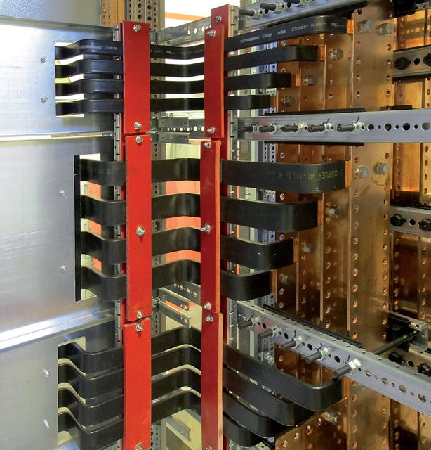 Detalhe do sistema de barramentos de cobre com suportes isolantes no interior do quadro